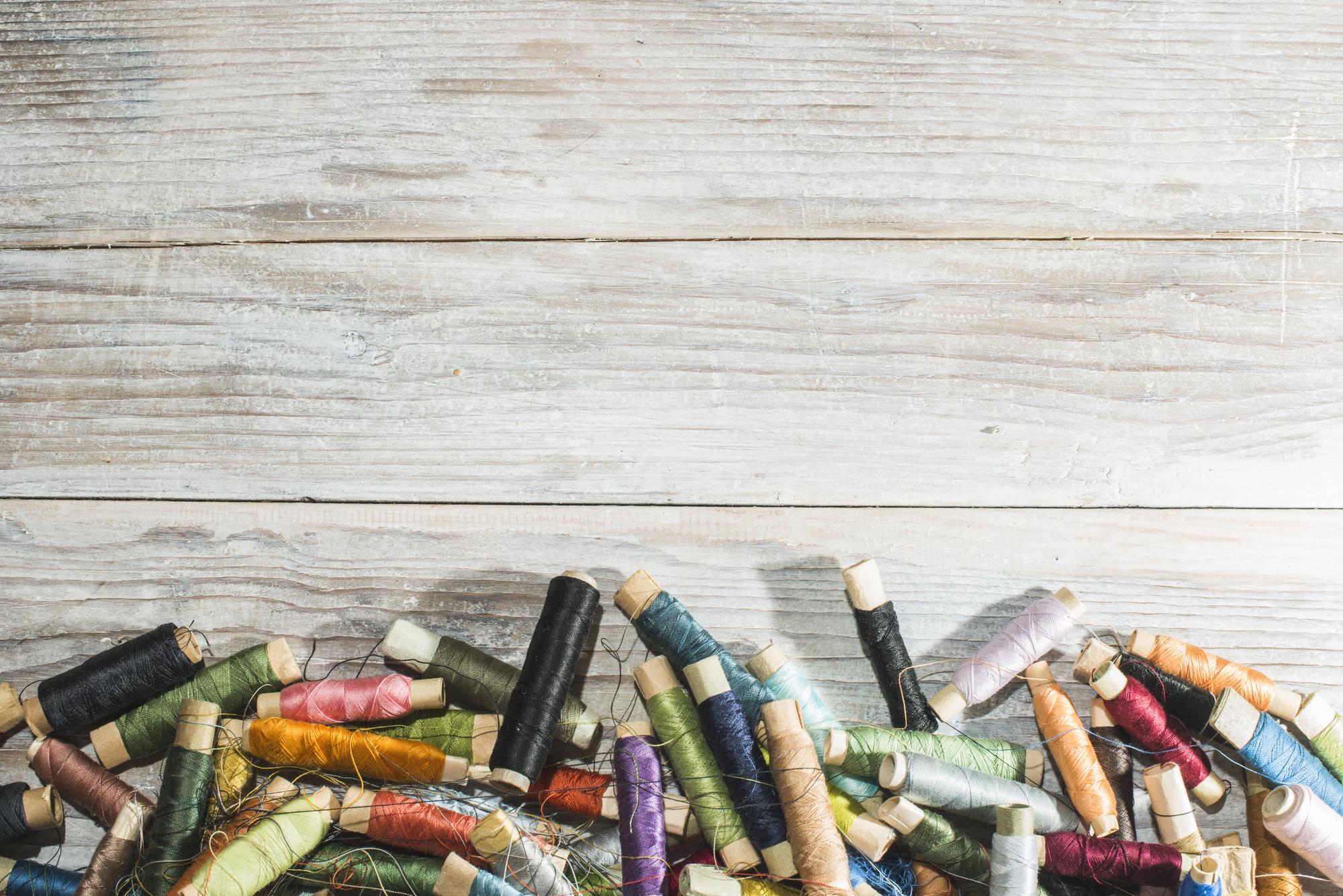 studio table with threads, needles and sketches